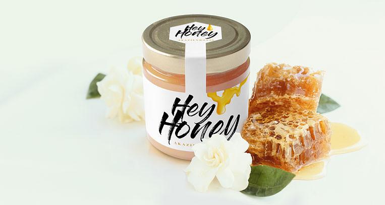 Honigglas mit modernem Etikett dekoriert mit Blumen und Honigwaben.